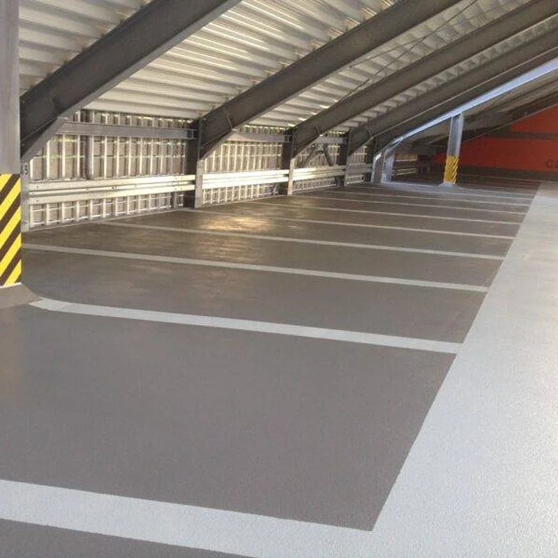 Fertig beschichtete Parkhausfläche mit Stellplatzmarkierungen, Fahrspuren und Stütze mit Anfahrschutz.